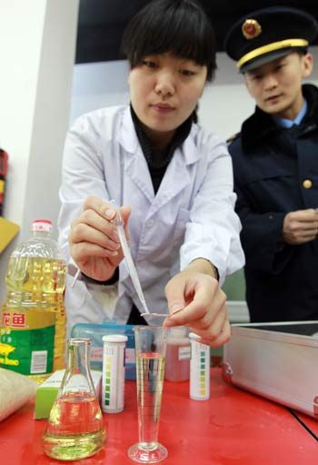 A staff member of the Beijing bureau of industry and commerce tests cooking oil during a safety check at a local produce market on Jan 27.