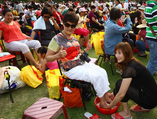 A woman washes her mother's feet in Pingdong county, Taiwan, May 7, 2011. About 4,000 people gathered in a park in the county to welcome the Mother's Day.[