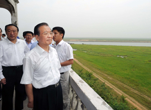 Chinese Premier Wen Jiabao looks at lake-turned grassland as the result of lingering drought in Yongxiu county of East China's Jiangxi province June 5, 2011. [Photo/Xinhua] 