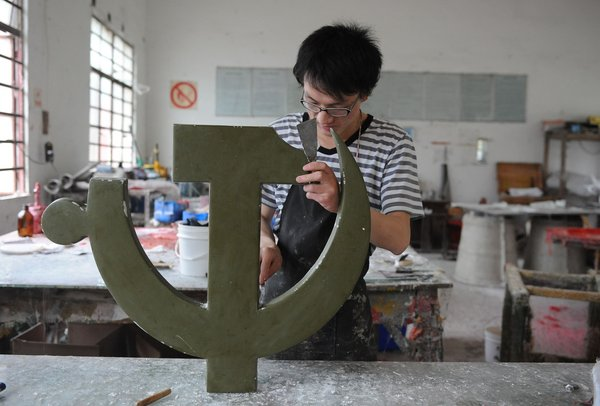 A man makes a Party emblem in a factory in Anqing city, East China's Anhui province, June 28, 2011. The factory is one of three in China that are allowed by the Organization Department of the CPC to make Party emblems. 