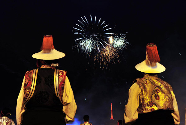 Tibetans watch fireworks light up the sky at Potala Palace Square in Lhasa to celebrate the 60th anniversary of the peaceful liberation of Tibet on July 19, 2011. [Photo/Xinhua] 