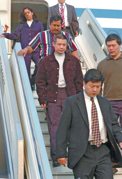 Yu Zhendong (middle) arrives in Beijing in 2004 on a repatriation flight from the United States. The former president of Bank of China's Kaiping branch, was accused of embezzling of 4 billion yuan.