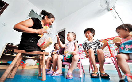 Xu Yuehua, better known as 'Mom on Stool,' is seen with some of the orphans at a social welfare institute in central China's Hunan Province. 