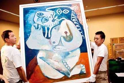 Workers in white gloves move 'L'etreinte' by Pablo Picasso in preparation for the China debut of a traveling exhibition of selected works by the legendary artist which opens next Tuesday in the Shanghai World Expo China Pavilion.