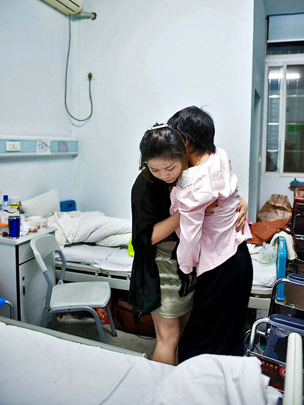 Fan Yajing, a 22-year-old arts student, holds her paralyzed mother in her arms to move her to bed. Fan has won widespread admiration after details of her struggle to juggle her studies while caring for her bedridden mother are featured in her microblog. Fan's mother suffered a cerebral hemorrhage in April.