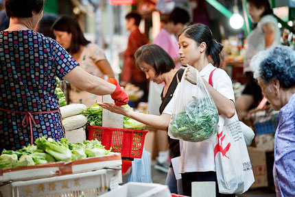 A shopper buys produce at a market in Hong Kong. The city's inflation accelerated in September after moderating from a 15-year high the previous month.