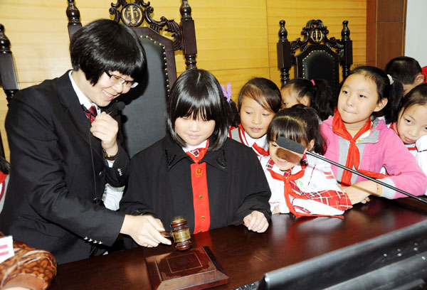 Primary students in Yunyang county, Chongqing, attend a mock court session during an open day at the county court. Rao Guojun / For China Daily   