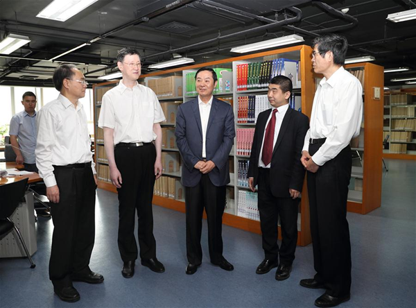 Liu Qibao (C), member of the Political Bureau of the Communist Party of China (CPC) Central Committee and head of the committee's Publicity Department, listens to a brief report as he inspects China Braille Publishing House before China's national day for the disabled, which falls on May 21, in Beijing, capital of China, May 19, 2017. [Photo/Xinhua]