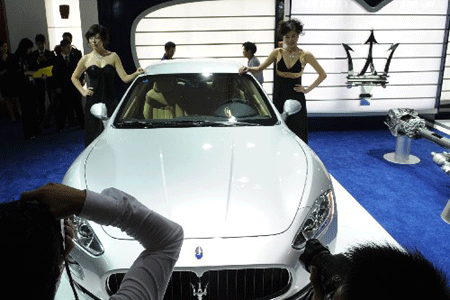 Deux photographes prennent lundi des photos du roadster GT Maserati qui sera exposé au 5e salon international de l'automobile de Chine à Guangzhou, chef-lieu de la province du Guangdong.