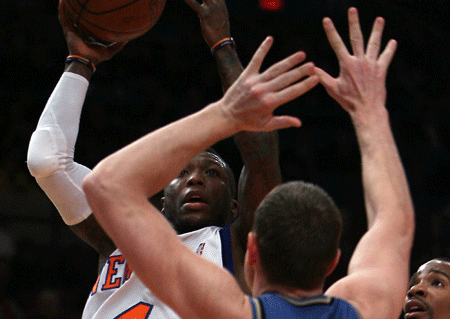 New York Knicks Nate Robinson (Rear) jumps to pass the ball during the NBA game against Washington Wizards in New York, the United States, Jan. 14, 2009. Knicks won 128-122. 