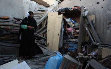 A Palestinian woman inspects her damaged house after an Israeli attack in central Gaza strip July 2, 2009. Israel shelled the Hamas-controlled Gaza on Thursday, killing a Palestinian teenage girl, hospital workers said. An Israeli military spokeswoman said there had been clashes between soldiers and Palestinian militants near a border crossing in the area. [Xinhua]