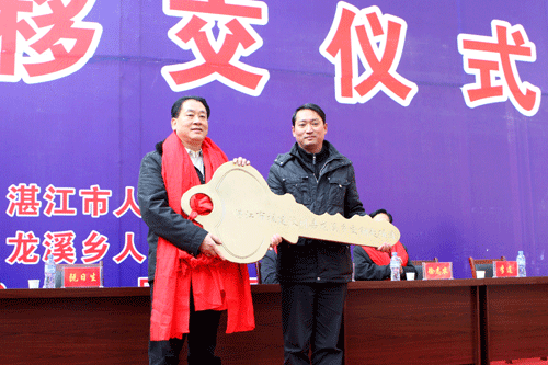 Ruan Risheng, major of Zhanjiang City, presents residents of Longxi with the key to their village.