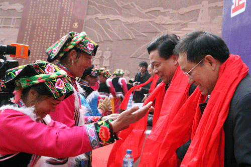 Villagers present traditional red scarves to officials from Zhanjiang City as a mark of gratitude for Zhanjiang's help in reconstruction.