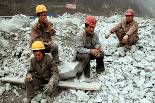 Construction workers take time out from building a dam on the Min River. The old dam was destroyed by the May 12 Sichuan earthquake. 