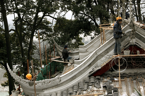 Workers repair on the roof of the temple.
