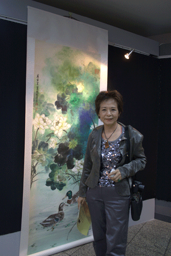 Zhao Songjun, a painter from Taipei and her pictures at the Beijing-Taipei Painting Exhibition which kicked off at the China Millennium Monument in Beijing, June 24, 2010.