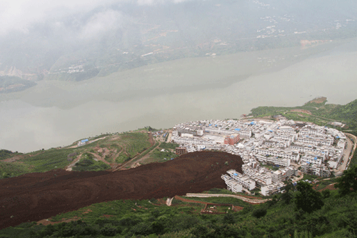 A rain-triggered landslide hit villages in Hanyan county, Southwest China&apos;s Sichuan province, July 27, 2010. The sudden disaster left 21 people missing, and 58 houses collapsed. About 4,000 villagers are being evacuated from the area. [Xinhua]