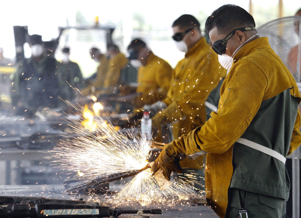 Police officers use welding torches to break down weapons for disposal in Panama City, Oct 27, 2010. The weapons are from a batch of firearms, numbering more than 1,800, which were confiscated from criminals and also from exchanges by trade for medicine and food, according to the police press office. [China Daily/Agencies] 