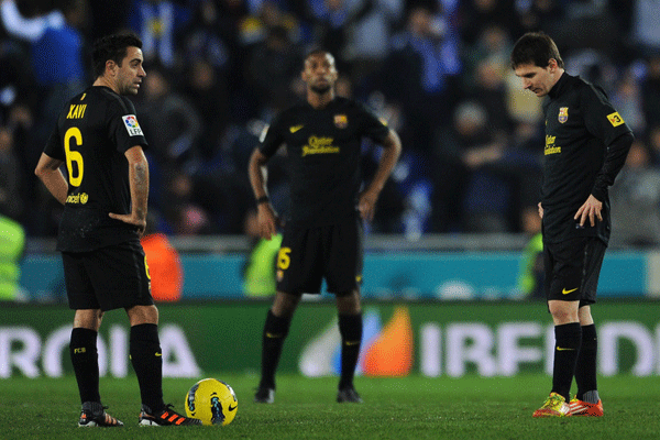 Barcelona players Xavi(left), Keita(middle) and Messi(right) react after drawing 1-1 with Espanyol during a La Liga match on Jan.9, 2012.