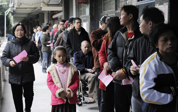 People line up outside a polling station as they wait to cast their votes during Taiwan leader election which starts on Saturday, Jan.14, 2012.