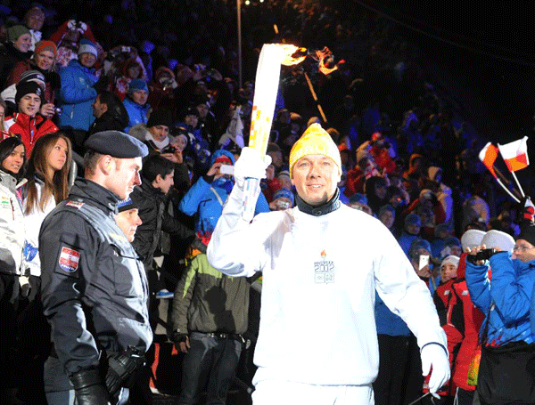 Fritz Strobl, a ski racer from Austria, runs Olympic torch relay during the opening ceremony of the first Winter Youth Olympic Games in Innsbruck, Austria, Jan. 13, 2012. (Xinhua/Xu Liang) 