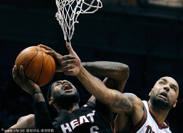 Miami Heat's Lebron James (left) puts up a shot against Milwaukee Bucks' Drew Gooden (right) during the second half of an NBA basketball game on Wednesday, Feb. 1, 2012 in Milwaukee. 