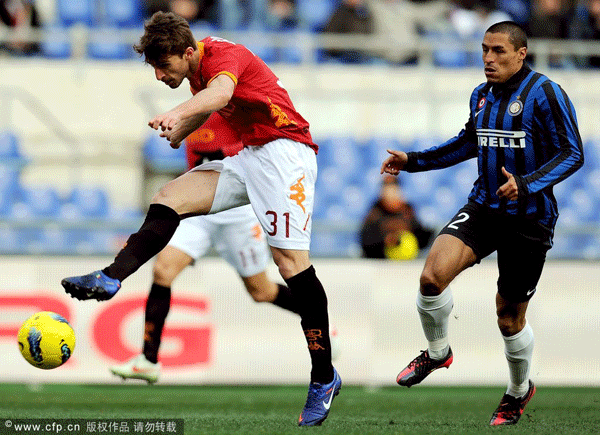 AS Roma's Italian forward Fabio Borini (L) in action against Inter's Ivan Cordoba (R) on his way to score the 3-0 lead during the Italian Serie A soccer match between AS Roma and Inter Milan at the Olympic Stadium in Rome, Italy, on February 5, 2012.
