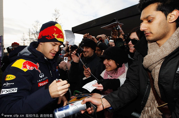 Sebastian Vettel of Germany and Red Bull Racing signs autographs for fans while attending the Red Bull Racing Home Run event on December 10, 2011 in Milton Keynes, England.