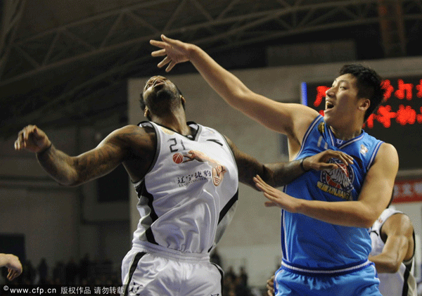  Tang Zhengdong of Xinjiang and Liaoning's Powell position for a rebound during a CBA game between Xinjiang and Liaoning on February 8, 2012. 