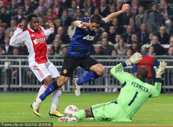 Javier 'Chicharito' Hernandez of Manchester United clashes with Vurnon Anita (L) and Kenneth Vermeer of AFC Ajax during the UEFA Europe League round of 32 first leg match between AFC Ajax and Manchester United at Amsterdam Arena on February 16, 2012 in Amsterdam, Netherlands. 