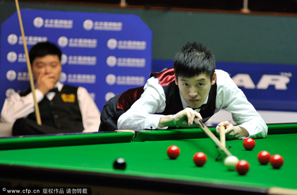 Jin Long of China plays in the first round match against compatroit Ding Junhui at the Haikou World Open on Feb. 28, 2012.