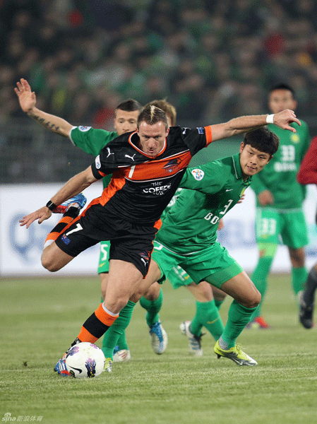 Besart Berisha (R) of the Brisbane Roar vies the ball with Yu Yang (L) of Beijing Guo'an during their AFC Champions League Group F football match at the Workers Stadium in Beijing on March 20, 2012.