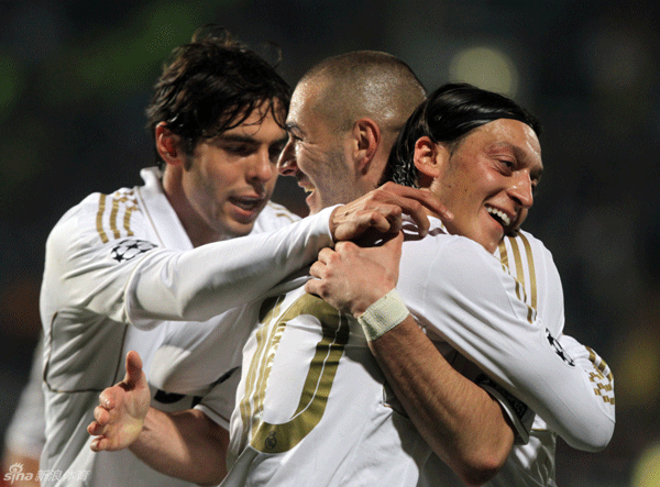 Karim Benzema (C) of Real Madrid celebrates with teammates Kaka (L) and Mesut Ozil after scoring his team's third goal during the UEFA Champions League quarter-final first leg against APOEL FC on March 27, 2012.