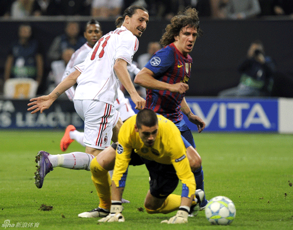 Zlatan Ibrahimovic of AC Milan in action against Carles Puyol and goalkeeper Victor Valdes of Barcelona during their UEFA Champions League quarter-final first leg at San Siro on March 28, 2012.