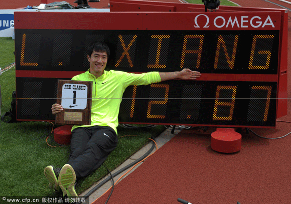 Liu Xiang poses with the performer of the meet award and scoreboard after winning the 110m hurdles in a wind-aided 12.87 at the 2012 Prefontaine Classic.
