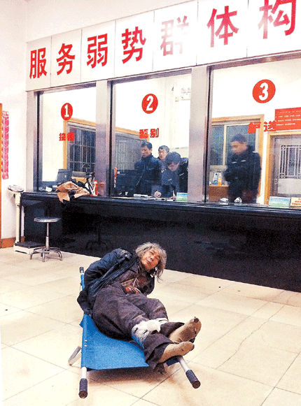 A homeless man, tied up, lies on a stretcher in the reception hall of a shelter center in Changsha on Monday night. An investigative journalist of a Changsha newspaper posing as a vagrant said he was beaten up by staff at the center after being sent there. [Photo/Shanghai Daily]