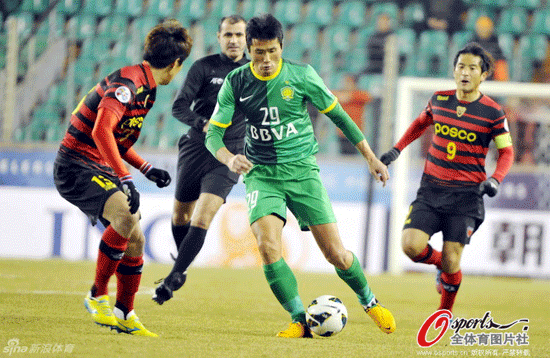 Shao Jiayi of Beijing Guoan tries to dripple past defender in a AFC Champions League match between Beijing Guoan and Pohang Steelers on Feb.27, 2013.