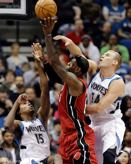 LeBron James goes up for a basket against two defenders in Miami Heat's win over Minnesota Timberwolves on March 4, 2013.