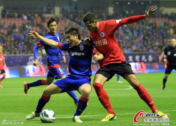  Players vie for the ball in a CSL match between Shenhua and Whowin on March 31, 2013.