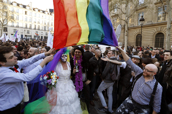 People gather to celebrate the passage of a law allowing same-sex couples to marry and adopt children, in Paris April 23, 2013.[Photo/Agencies] 