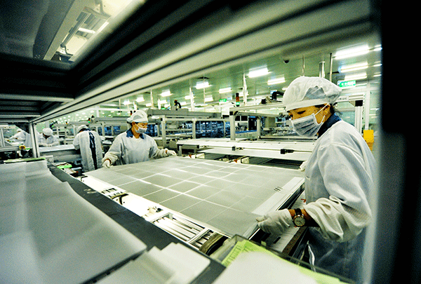 Workers at a plant of JinkoSolar in Jiangxi province produce solar polycrystalline silicon sheets. [Photo/China Daily]