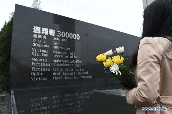 A resident mourn the Nanjing Massacre victims at the Memorial Hall of the Victims in Nanjing Massacre by Japanese Invaders on the Qingming Festival in Nanjing, capital of east China's Jiangsu Province, April 5, 2015. [Photo: Xinhua]