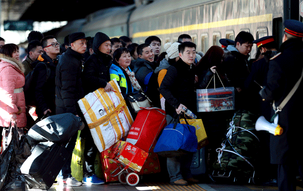 Passengers wait to get on a train at Beijing West Railway Station on Friday. [Photo/China Daily]