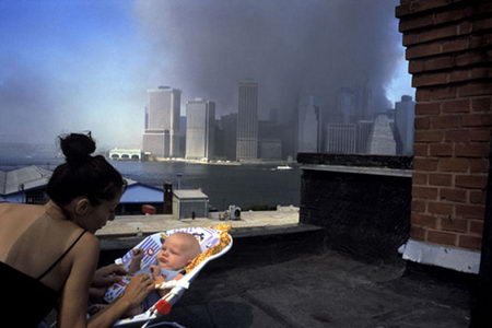 在世贸中心双子楼坍塌后，一位女子和她3个月大的孩子在布鲁克林屋顶。摄影师所要表现的是：尽管人们彼此陷入恐惧，但是面对灾难生活将继续。