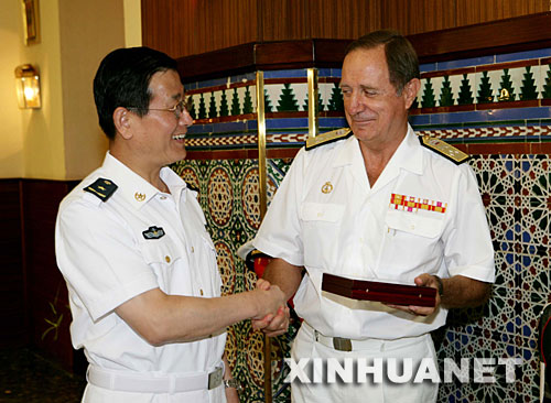 9月14日，中国海军出访舰艇编队指挥员苏支前少将（左）与西班牙海军舰队司令费尔南多·阿马达中将互赠礼品。新华社记者查春明摄