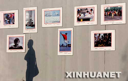 9月20日，一名游客在欣赏展出的图片。 当日，在山西平遥古城举行的2007平遥国际摄影大展进入第二天，1万余幅来自世界47个国家和地区的摄影精品吸引了众多的摄影爱好者。新华社记者燕雁摄
