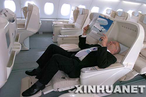 一名工作人員在空客A380商務艙內展示座椅的功能