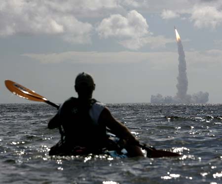 遊客駕獨木舟從水面上觀看“發現”號太空梭升空。