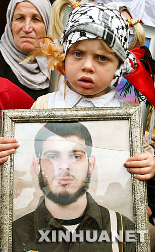 11月19日，一名巴勒斯坦兒童手持被以色列關押親屬的照片參加在加沙舉行的抗議集會。新華社記者納賽爾攝