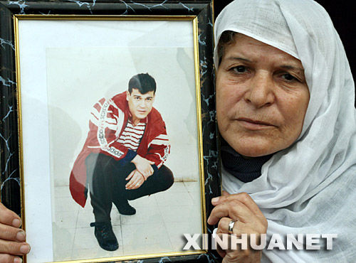 11月19日，一名巴勒斯坦婦女手持被以色列關押家屬的照片參加在加沙舉行的抗議集會。新華社記者納賽爾攝